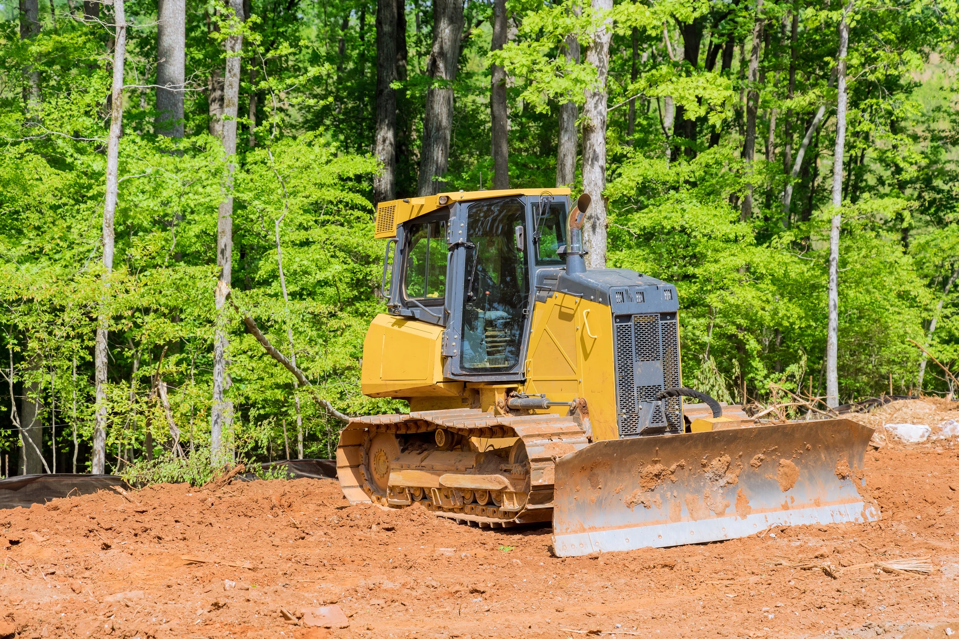 Chantier de terrassement en extérieur avec pelleteuse compacte à chenilles caoutchouc effectuant des travaux d'excavation