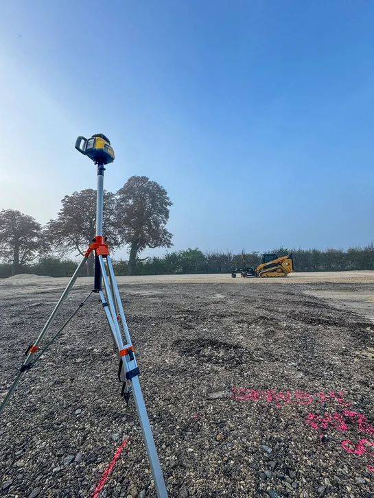 Conducteur de poids lourd souriant dans la cabine de son camion, portant un gilet de sécurité orange haute visibilité et une chemise à carreaux bleue