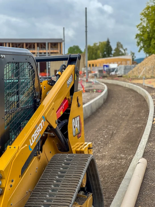 Chantier de construction avec deux professionnels en équipements de sécurité analysant des plans
