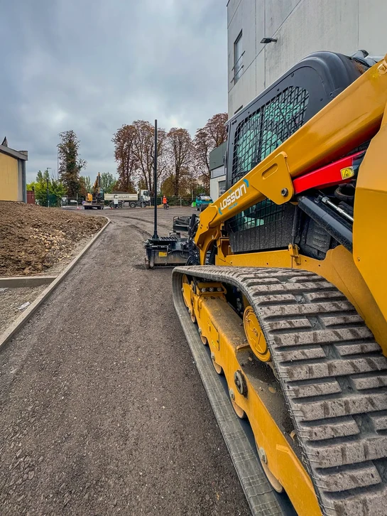Chantier extérieur avec pelleteuse hydraulique sur chenilles Caterpillar en position de travail sur terrain de terrassement