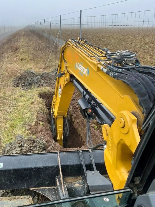 Chantier de construction en extérieur avec pelleteuse hydraulique orange en action