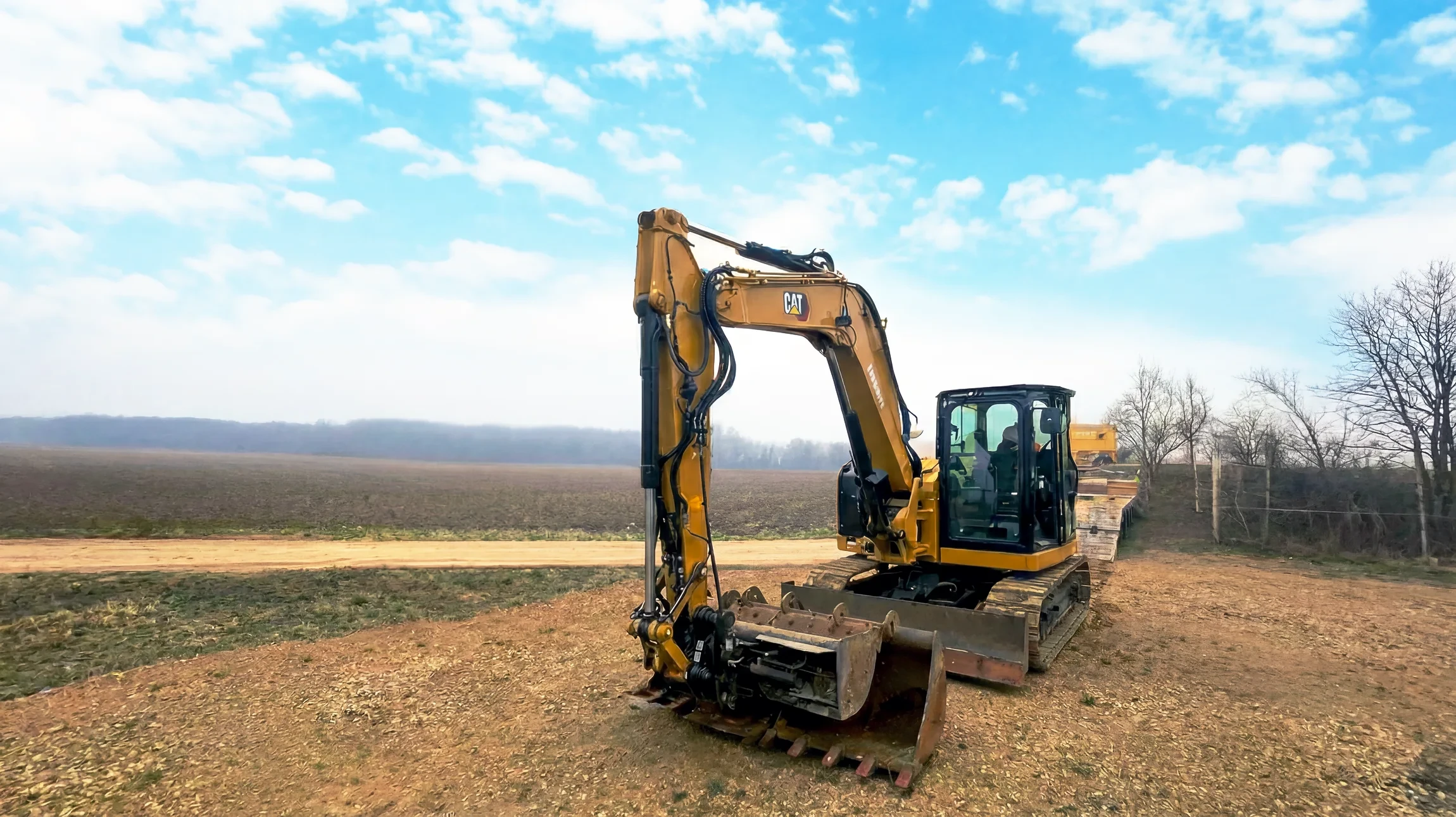 Vue aérienne d'un chantier de terrassement avec deux pelleteuses hydrauliques jaunes en activité sur terrain excavé
