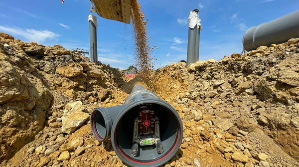 Une mini pelle enl&egrave;ve les d&eacute;bris pendant l'am&eacute;nagement paysager